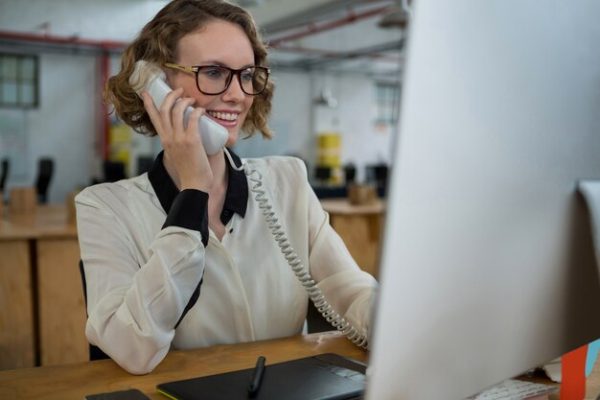 mulher-falando-no-telefone-fixo-na-mesa_107420-88820